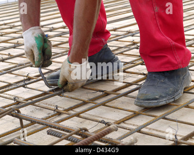 Closeup Schuss von bar Bender Hände Stahl Bewehrungsstäbe mit Bindedraht fixieren Stockfoto