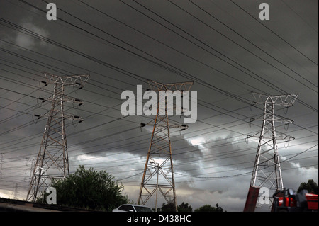 Ein Blick auf Strommasten mit einem dramatischen stürmischen Himmel im Hintergrund. Stockfoto