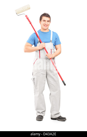 In voller Länge Portrait von zuversichtlich Maler in Uniform mit einem Pinsel auf weißen Hintergrund isoliert Stockfoto