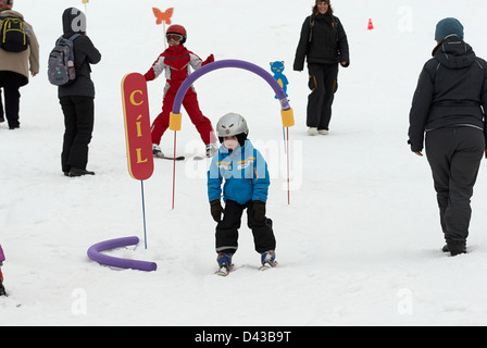 Kinder üben ihre Form in der Skischule Stockfoto