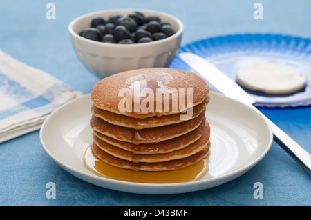 Nahaufnahme von einem Stapel von Pfannkuchen mit Ahornsirup. Butter und Beeren im Hintergrund. Stockfoto