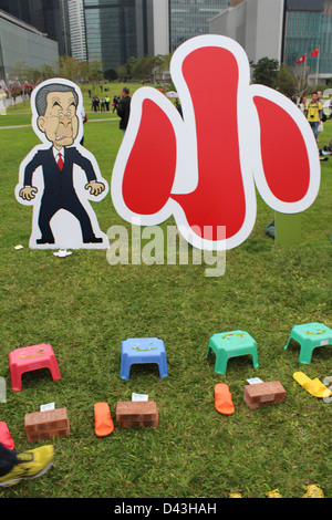 'Da Siu Yan' oder "hit kleine Leute" oder "Fluch". Hong Kong Führer CY Leung neben einem Ausschnitt des Zeichens für "kleine". Stockfoto