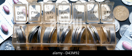 Münzen im Pille Organizer Stockfoto