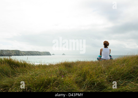 Frau sitzt und Blick in die Ferne, am Strand, Camaret-Sur-Mer, Halbinsel Crozon, Finistere, Bretagne, Frankreich Stockfoto