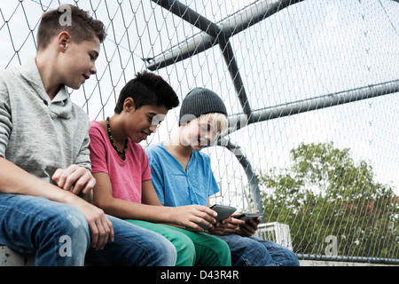 Drei jungen spielen von Videospielen in Spielplatz, Mannheim, Baden-Württemberg, Deutschland Stockfoto