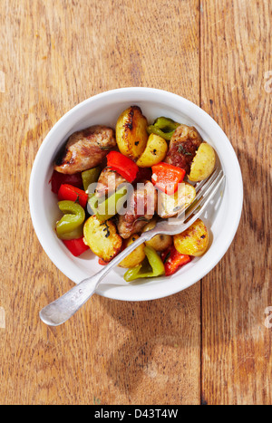 Draufsicht der Wurst mit Kartoffeln und Paprika in Schüssel mit Gabel Stockfoto