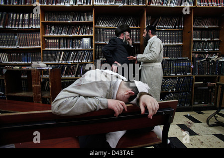 Orthodoxer Jude schläft auf einer Bank in einer Jeschiwa, einer jüdischen Bildungseinrichtung, die sich auf das Studium traditioneller religiöser Texte im Viertel Mea Shearim konzentriert, einer ultra-orthodoxen Enklave in West-Jerusalem Israel Stockfoto