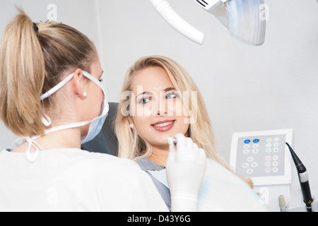 Junge Frau in Zahnarztpraxis für Termin, Deutschland Stockfoto