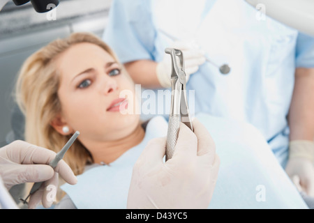 Junge Frau betrachten Dentalinstrumente während Termin, Deutschland Stockfoto