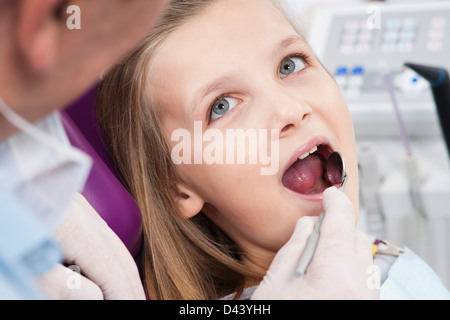 Nahaufnahme des Zahnarztes, die Überprüfung des Mädchens Zähne während Termin, Deutschland Stockfoto