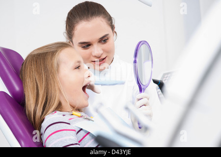 Zahnarzt, Spiegel und berühren Mädchens Zahn während des Termins, Deutschland Stockfoto