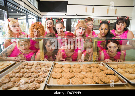 Frauen tragen Teufelshörnern auf eine Bäckerei, Oakland, Alameda County, Kalifornien, USA Stockfoto