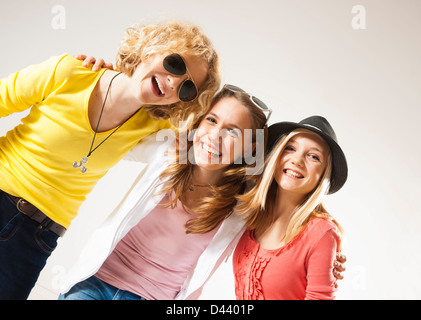 Porträt von drei, coole Mädchen im Teenageralter, Blick in die Kamera Lächeln, gedreht Diagonal Studio auf weißem Hintergrund Stockfoto