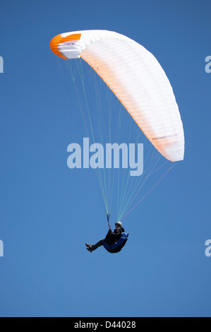 Männliche Gleitschirm genießt einen Flug in einem blauen Himmel im Ager, Lleida, Katalonien, Spanien. Stockfoto