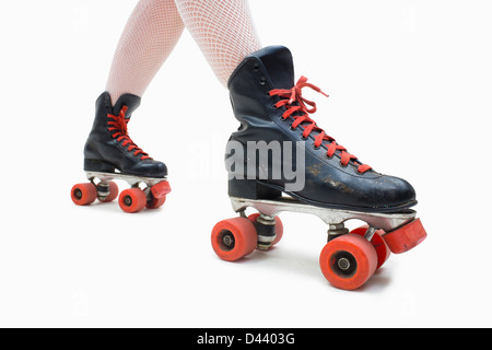 Frau trägt Netzstrümpfe und Old Fashioned Rollschuhe Stockfoto