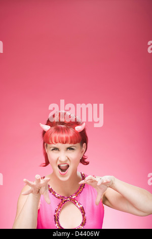 Porträt der Frau mit Teufelshörnern imitiert eine große Katze Stockfoto