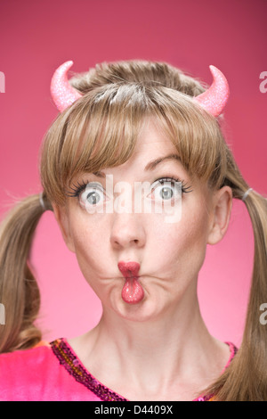 Porträt Frau mit Teufelshörnern und Making Faces Stockfoto