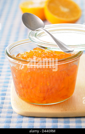 Nahaufnahme der selbstgemachte Orangenmarmelade mit Löffel auf Schneidebrett Stockfoto