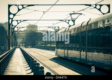 Die Porto Metro Bahn kreuzt die Dom Luis 1 Brücke über den Fluss Douro bei sonnigen Tag. Getönten Bild Stockfoto