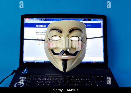 Eine anonyme Maske (auch: Guy Fawkes Maske oder Vendetta Maske) wird auf einem Laptop dargestellt, auf dem die Facebook-Internetseite in 2011 angezeigt wird. Fotoarchiv für ZeitgeschichteS.Steinach Stockfoto