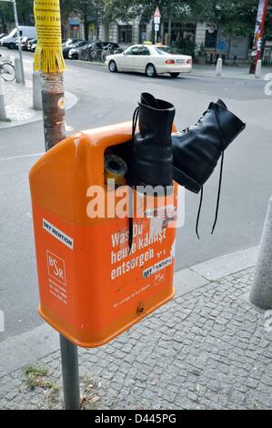 Sprungschuhe sind in einem orangefarbenen Mülleimer mit einem Aufkleber mit der Aufschrift „Was Sie heute entsorgen können...“ abgebildet. In Berlin, Deutschland, 17. September 2011. Fotoarchiv für ZeitgeschichteS.Steinach Stockfoto