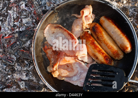 Camp auf der Glut eines offenen Brandes bekannt als Koch, Kochen Stockfoto