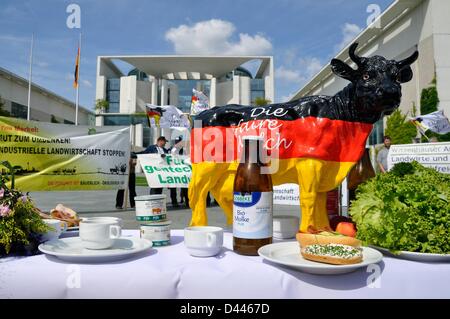 Eine Kuh in den Farben der deutschen Flagge schwarz, rot und golden ist hinter einem Frühstückstisch während einer Demonstration von Bauern vor dem deutschen Bundeskanzleramt in Berlin, Deutschland, am 09. Juni 2011 abgebildet. Fotoarchiv für Zeitgeschichte Stockfoto