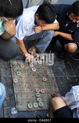 Chinesische Männer spielen chinesisches Schach (Xiangqi) auf dem Boden auf der Straße - Xi ' an, Provinz Shaanxi (China) Stockfoto