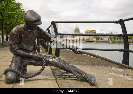 Horizontale Nahaufnahme einer Dock-Arbeiter-Statue am Kai des Flusses Liffey in Dublin an einem sonnigen Tag. Stockfoto