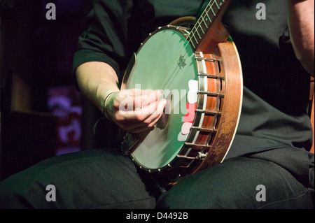 Horizontale Nahaufnahme des traditionellen irischen Musiker auf der Bühne ein Banjo zu spielen. Stockfoto