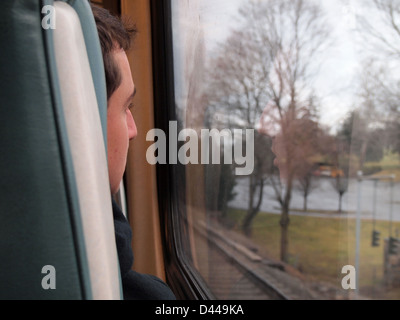 Pendler-Zug-Passagier mit Blick auf die vorbeiziehende Landschaft, New York, USA, 14. Januar 2013, Katharine Andriotis © Stockfoto