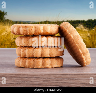 Einige Keks über einem hölzernen Hintergrund mit Feldern in den Rücken Stockfoto