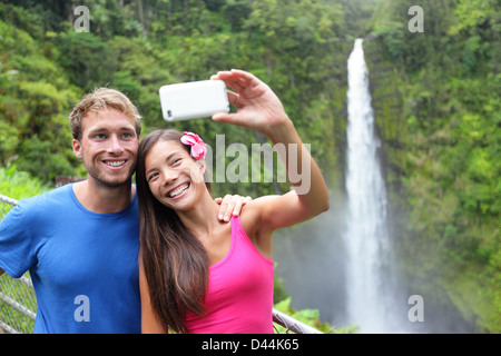 Glückliche junge multiethnischen paar Selbstportrait-Aufnahme mit Kamera-Handy auf Hawaii, große Inseln, Akaka Wasserfälle Stockfoto