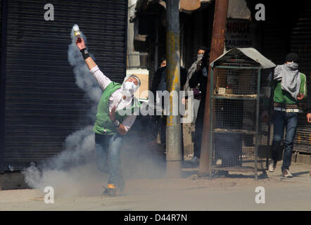 5. März 2013 - A Kashmiri Demonstranten werfen wieder eine Träne Rauch Shell auf indische Polizisten bei einem Zusammenstoß zwischen Demonstranten und indische Polizei in Srinagar, der Sommerhauptstadt des indischen Kaschmir auf 03.05.2013, normales Leben wurde für den zweiten Tag in Folge heute durch einen Marsch durch eine Gruppe von Separatisten, die Residenz des kaschmirischen Student namens getroffen , wer fand man in seinem Hostel Zimmer in Hyderabad hängen. Behörden haben Polizei und paramilitärische Personal in großer Zahl in der südlichen Kaschmir Pulwama Stadt, die Geburtsregion des Mudasir Kamran, (25), die gefunden wurde, hingen von der Decke seiner ho bereitgestellt Stockfoto