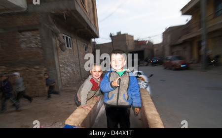 Uigurische Jungs spielen in der alten Stadt Kashgar. Stockfoto