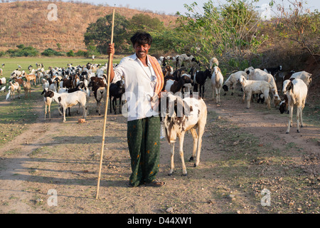 Indischen Hirten halten ein Ziegenbock bei den Hörnern in der indischen Landschaft. Andhra Pradesh, Indien Stockfoto