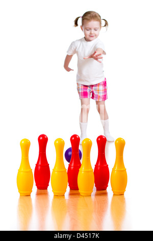 Kind Mädchen wirft Ball Spielzeug bowling-Pins abzureißen. Kegeln im Mittelpunkt. Stockfoto