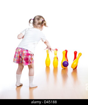 Kind wirft Ball niederzuschlagen Spielzeug bowling-Pins. Kind Mädchen steht wieder im Mittelpunkt. Stockfoto