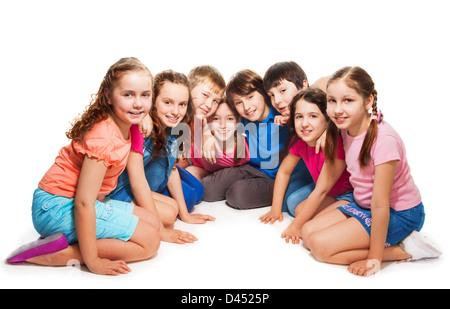 Gruppe von glücklich 10 Jahre alten Jungen und Mädchen sitzen zusammen im Halbkreis Stockfoto