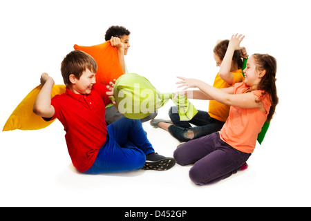 Niedlichen vier Teenager Kinder, jungen und Mädchen kämpfen mit Kissen, lachen und Spaß, isoliert auf weiss Stockfoto