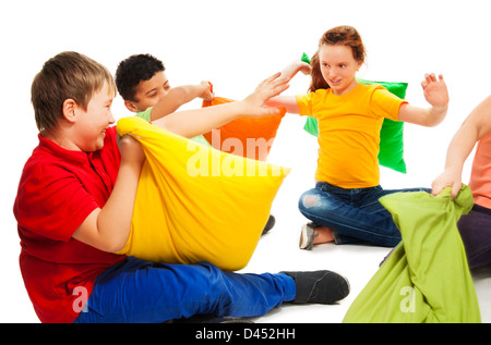 Glücklich drei Teenager-Kinder, jungen und Mädchen beginnen im Kampf mit Kissen, lachen und Spaß, isoliert auf weiss Stockfoto