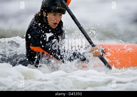 Frau in Wildwasser Kanu mit Entschlossenheit zu drehen Stockfoto