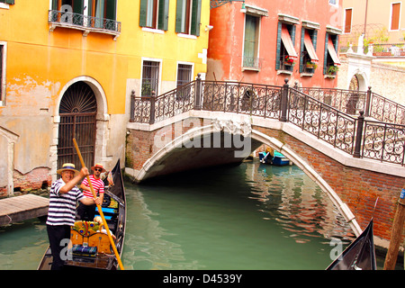 Zwei Gondolieri in der Gondel unter der Brücke, Venedig, Italien Stockfoto