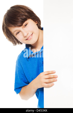 Hübsche 11 Jahre alte kaukasische junge, isoliert stehend und lächelnd Blick hinter weißen Plakat auf weiss Stockfoto