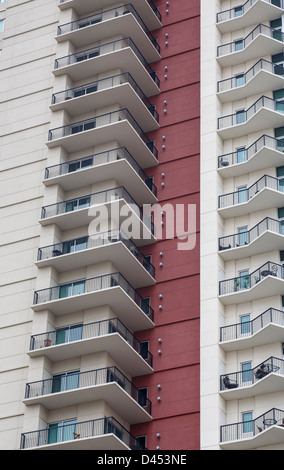 Eine Spalte mit Balcones auf einem Hochhaus Eigentumswohnung Turm mit einer roten Stuck Wand Stockfoto