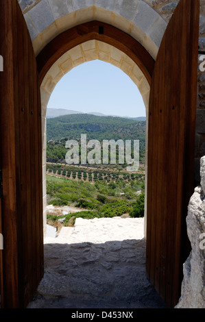 Rhodos. Griechenland. Blick auf Olivenhaine durch den Torbogen Kritinia Castello Castle an der Westküste der Insel Rhodos Stockfoto
