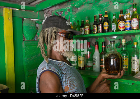 Murphy, der Besitzer Rootsmans Bar mit seinem Busch Rum, Carrs Bay, Montserrat Stockfoto