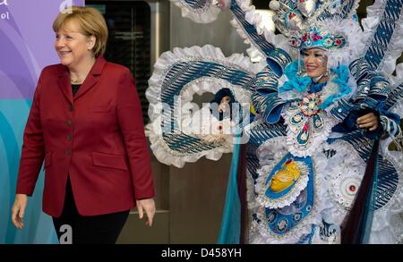 Berlin, Deutschland. 5. März 2013. Deutsche Bundeskanzlerin Angela Merkel (L) geht vorbei an einem indonesischen Tänzer vor der Eröffnungsfeier der ITB-Berlin in Berlin, Deutschland, 5. März 2013. Der Tourismus-Messe ist geöffnet von 06 bis 10. März 2013 und das diesjährige Partnerland ist Indonesien. Foto: SOEREN STACHE/Dpa/Alamy Live News Stockfoto