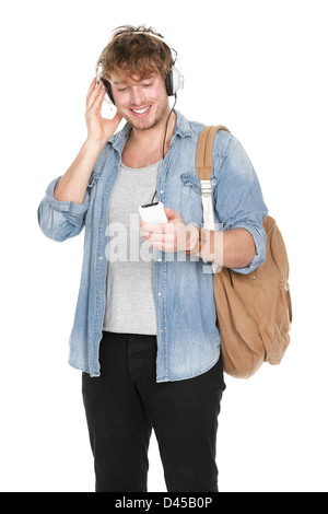 Junge hübsche männliche College-Student anhören von Musik im Kopfhörer auf Smartphone isoliert auf weißem Hintergrund Stockfoto