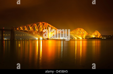 Die Forth Rail Bridge bei Nacht und voll beleuchtet mit der Forth Road Bridge im Hintergrund. Stockfoto